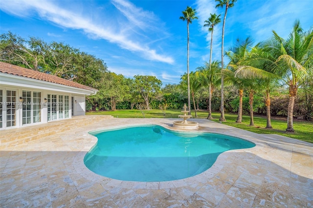 view of pool featuring a patio area and a lawn