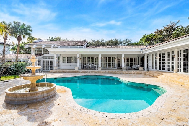 view of pool with french doors and a patio