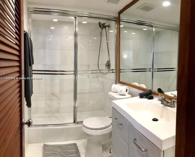 bathroom with vanity, toilet, and an enclosed shower