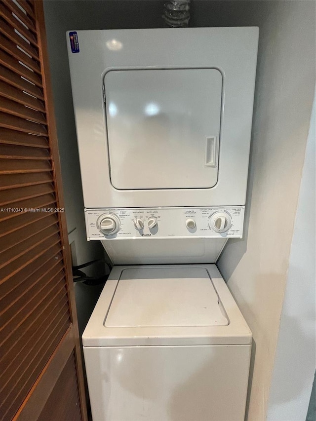 washroom featuring stacked washer / drying machine