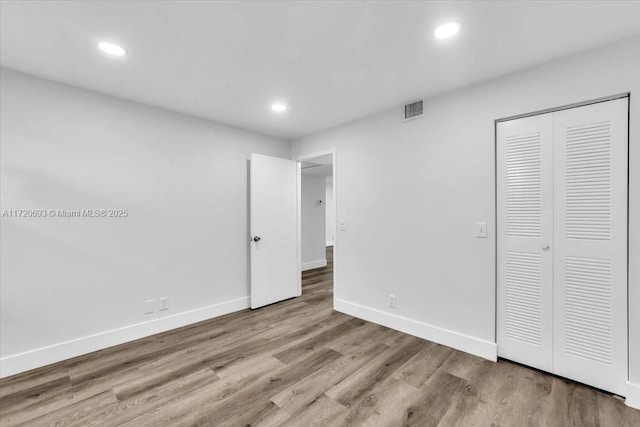 unfurnished bedroom featuring a closet and light wood-type flooring