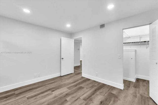 1201 SW 128th Ter Unit 303E, Pembroke Pines, FL 33027 - unfurnished bedroom featuring baseboards, wood finished floors, a walk in closet, recessed lighting, and a closet