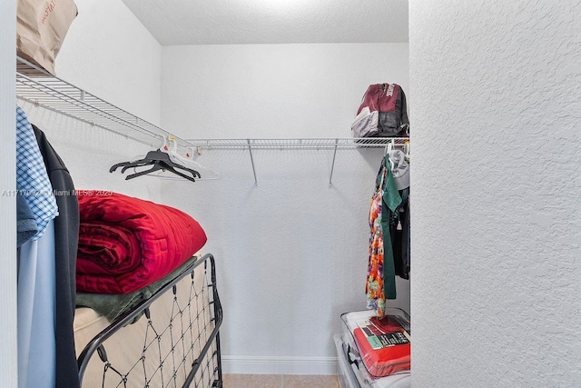 walk in closet with tile patterned flooring