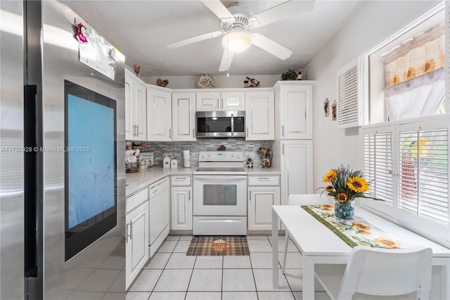 kitchen with tasteful backsplash, stainless steel appliances, ceiling fan, light tile patterned floors, and white cabinetry