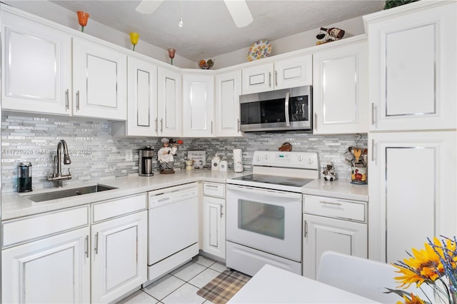 kitchen featuring white cabinetry, sink, light tile patterned flooring, and white appliances