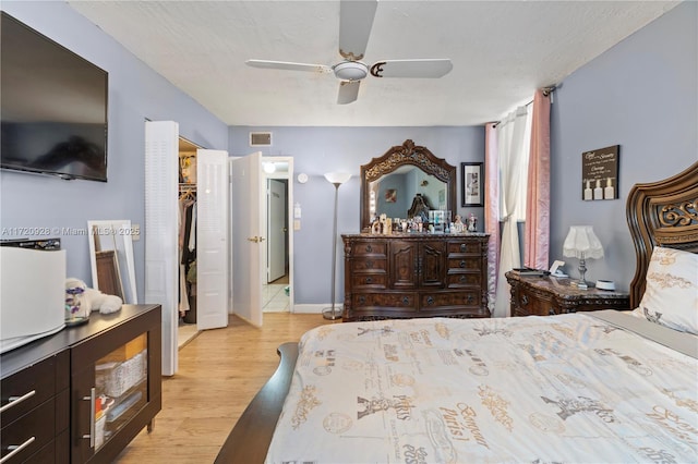 bedroom featuring ceiling fan, light hardwood / wood-style floors, a textured ceiling, and a closet