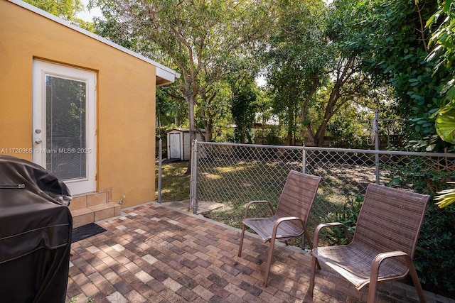 view of patio with a shed and grilling area