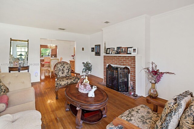 living room with a fireplace, hardwood / wood-style flooring, and crown molding