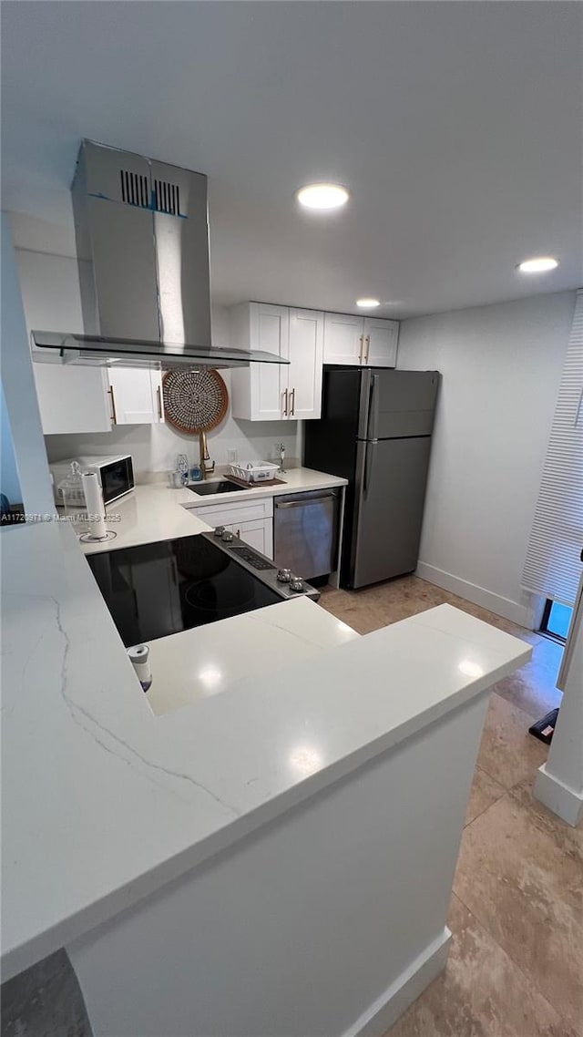 kitchen featuring dishwasher, freestanding refrigerator, island range hood, stove, and white cabinetry