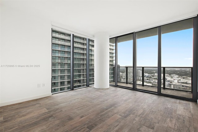 spare room with expansive windows and hardwood / wood-style flooring