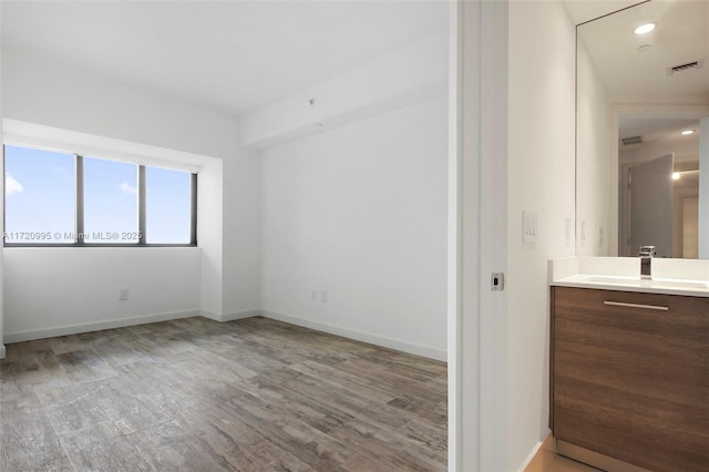 empty room with light hardwood / wood-style floors and sink