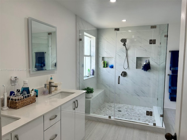 bathroom with vanity and a shower with door