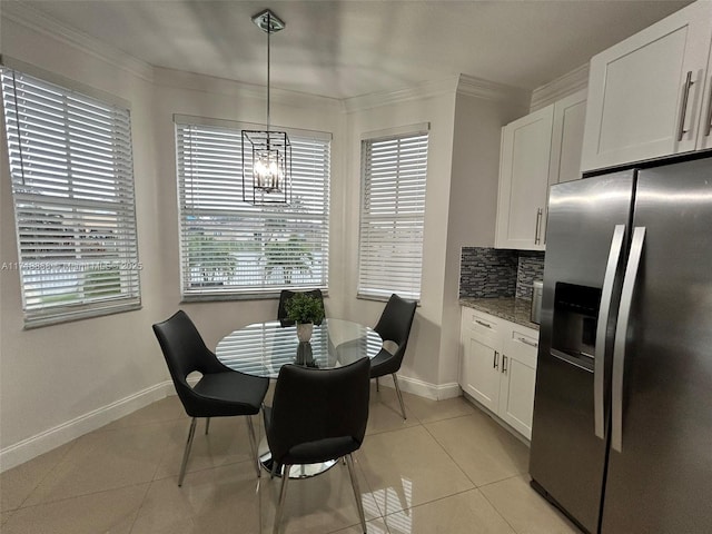 tiled dining room featuring ornamental molding and a notable chandelier