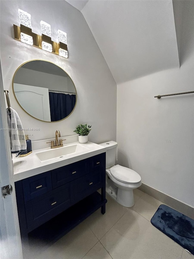 bathroom featuring tile patterned flooring, vanity, toilet, and lofted ceiling