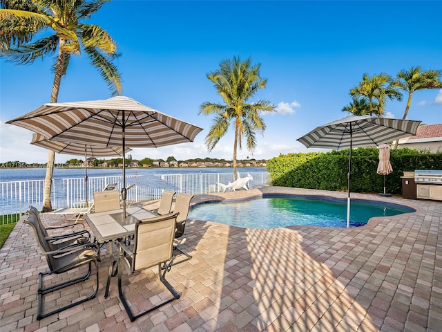 view of swimming pool featuring a patio and a water view