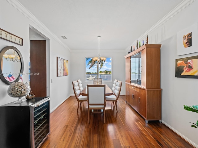 dining room with dark hardwood / wood-style floors, ornamental molding, beverage cooler, and an inviting chandelier