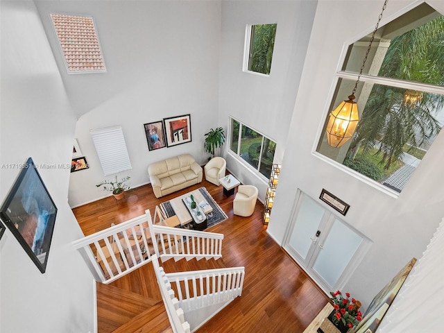 living room with a towering ceiling and dark hardwood / wood-style floors