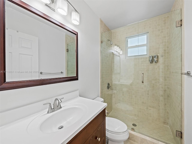 bathroom with vanity, toilet, and a shower with door