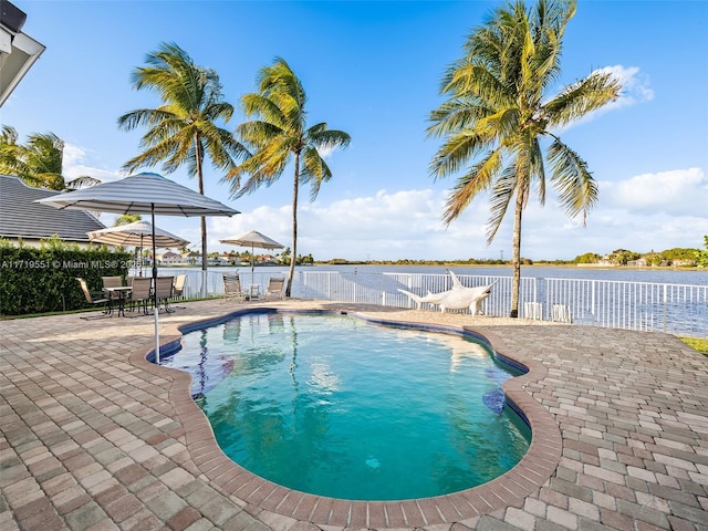 view of swimming pool featuring a patio area and a water view