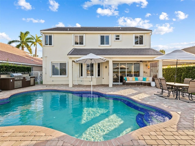 view of swimming pool featuring exterior kitchen, a grill, an outdoor hangout area, and a patio