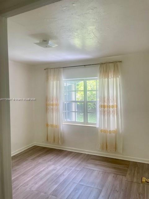 spare room with wood-type flooring