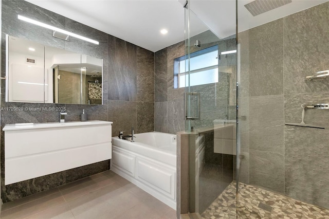 bathroom with tile patterned floors, vanity, tile walls, and plus walk in shower