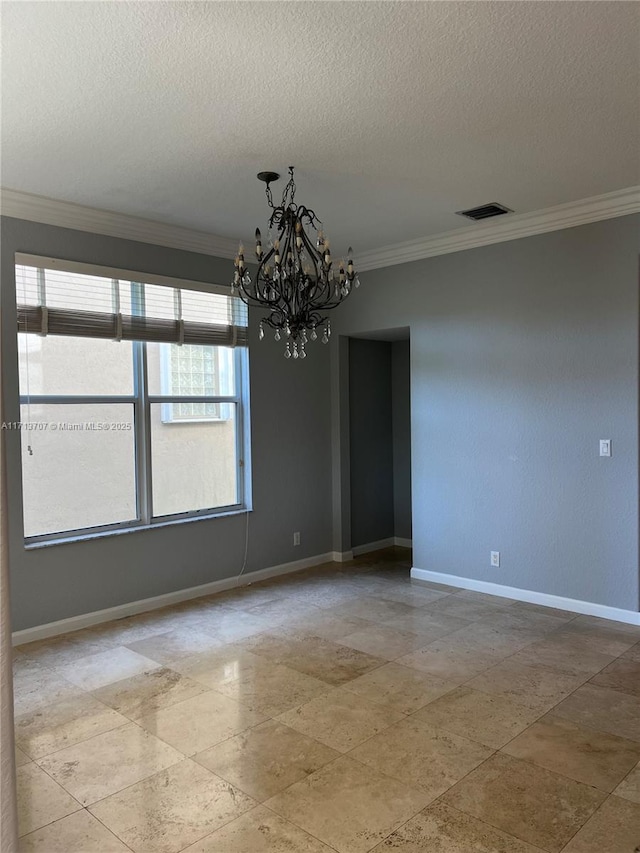 empty room featuring ornamental molding, a textured ceiling, and a notable chandelier