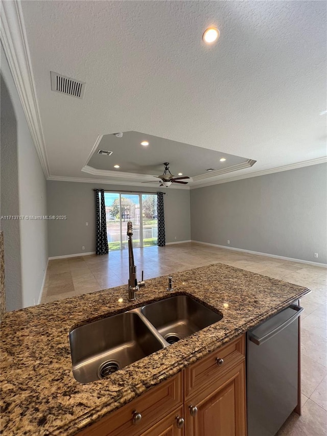 kitchen featuring dishwasher, sink, dark stone counters, a tray ceiling, and ornamental molding