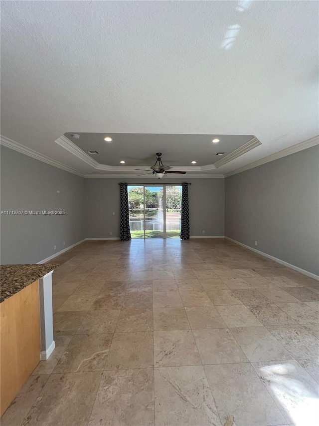 unfurnished room featuring ceiling fan, a raised ceiling, and crown molding