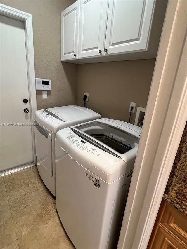 washroom with washing machine and clothes dryer and cabinets