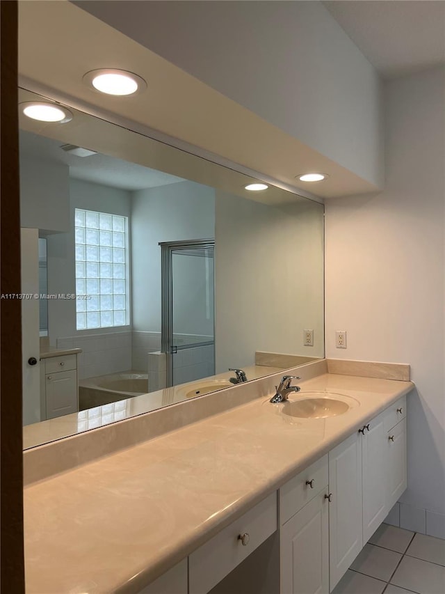 bathroom featuring a bathing tub, tile patterned flooring, and vanity