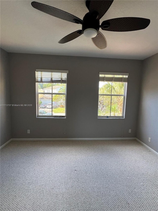 carpeted spare room featuring ceiling fan