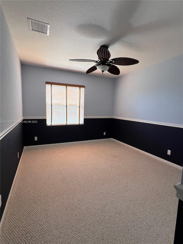 carpeted empty room featuring a textured ceiling and ceiling fan