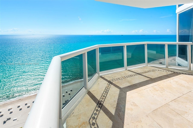 balcony featuring a water view and a view of the beach