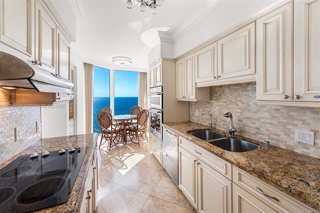 kitchen with sink, stainless steel dishwasher, cream cabinets, black electric cooktop, and a water view