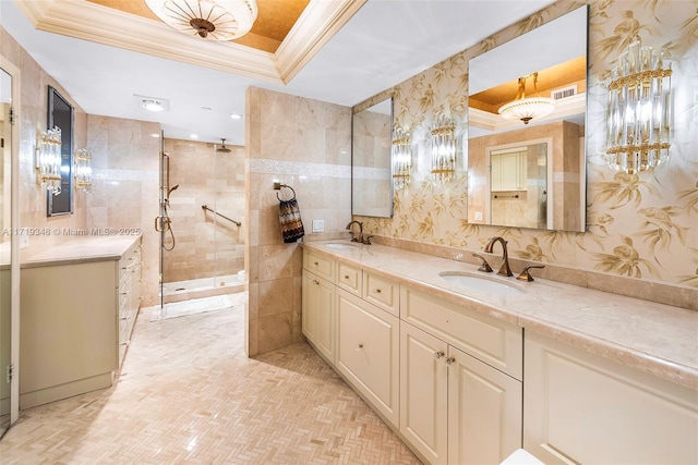 bathroom with parquet floors, vanity, a raised ceiling, crown molding, and tiled shower