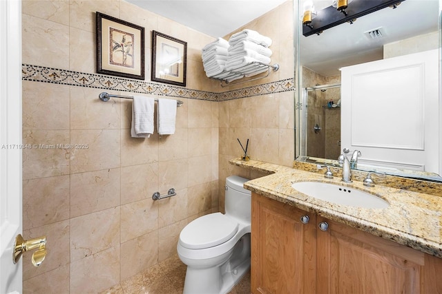 bathroom featuring toilet, vanity, tile walls, and walk in shower