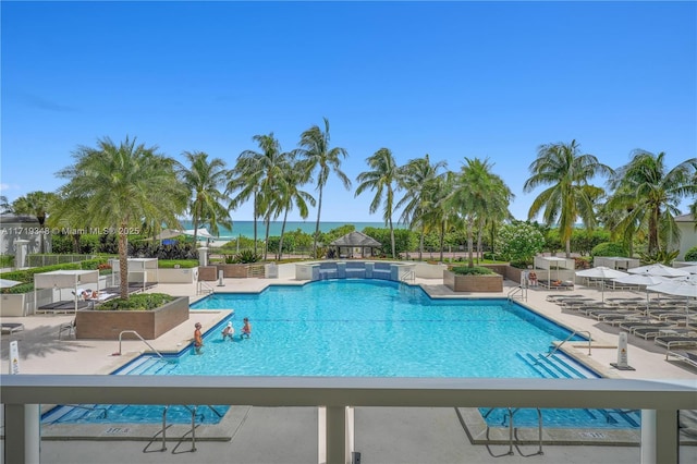 view of swimming pool with a water view and a patio