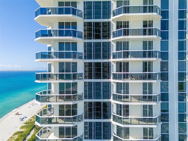 view of property with a water view and a beach view