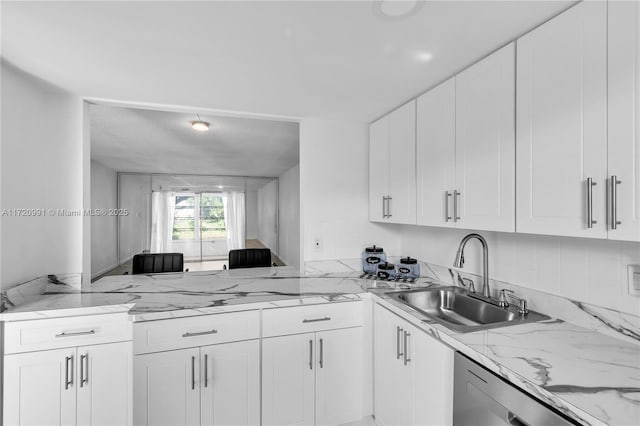 kitchen with white cabinets, light stone countertops, dishwasher, and sink