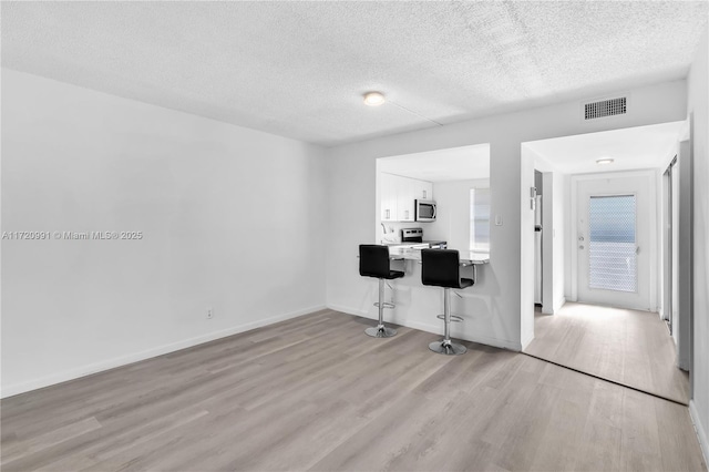 office space with a textured ceiling and light wood-type flooring