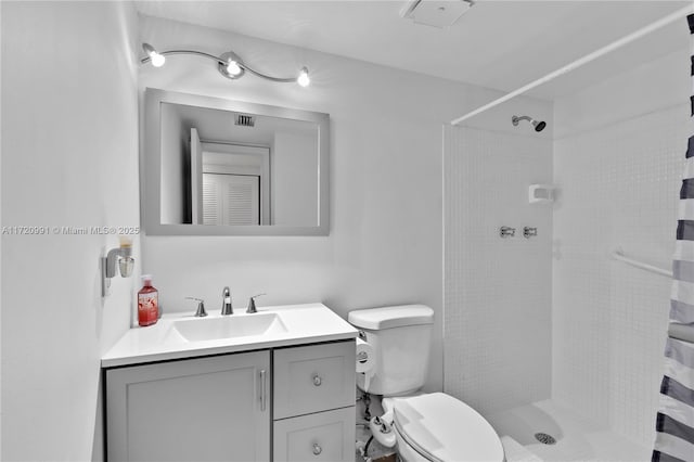 bathroom featuring vanity, toilet, and walk in shower