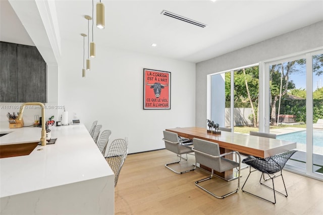 kitchen featuring a kitchen bar, light hardwood / wood-style flooring, built in refrigerator, and kitchen peninsula