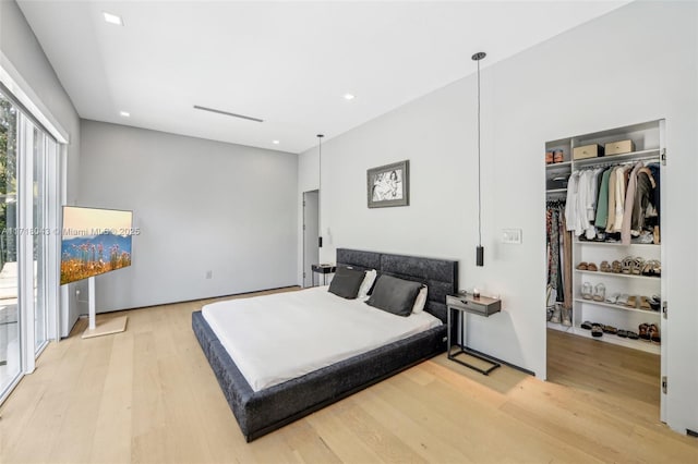 bedroom featuring light hardwood / wood-style flooring and two closets