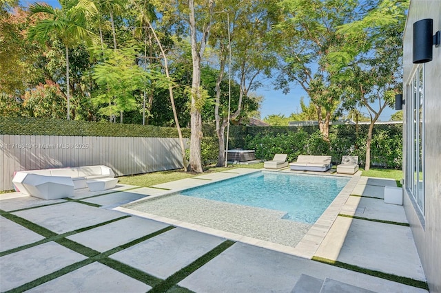 view of pool with a patio area, a hot tub, and a lawn