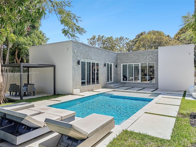 rear view of house with a patio area and a fenced in pool