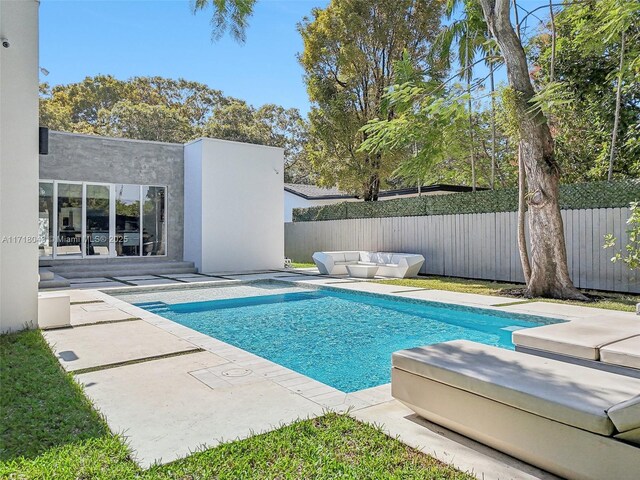 view of pool with an outdoor living space and a patio area