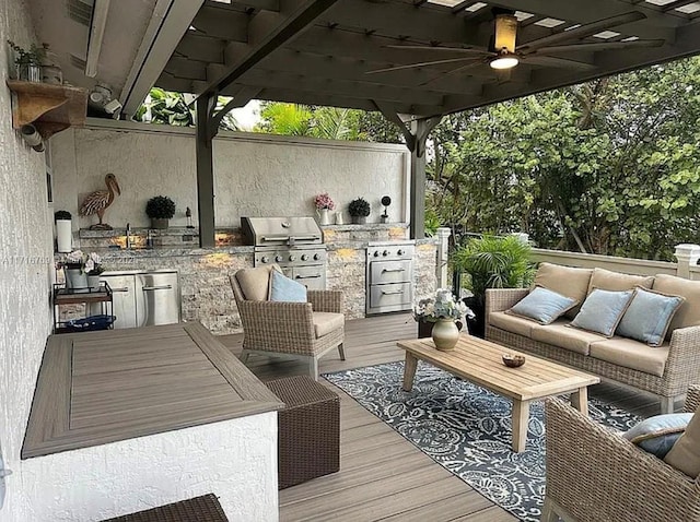 wooden deck featuring grilling area, ceiling fan, exterior kitchen, and an outdoor living space