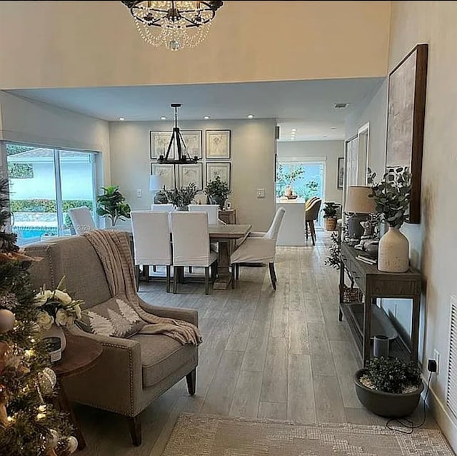 dining space featuring wood-type flooring and a notable chandelier