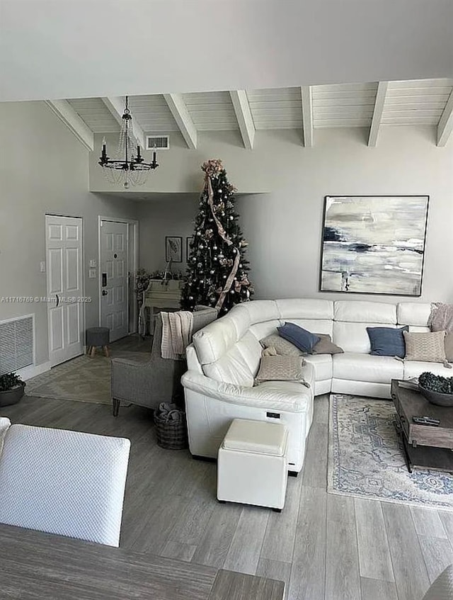 living room with beamed ceiling and a notable chandelier